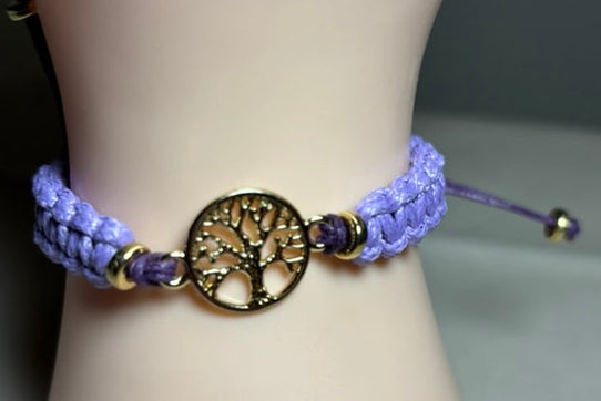 Purple braided bracelet with a gold tree of life charm