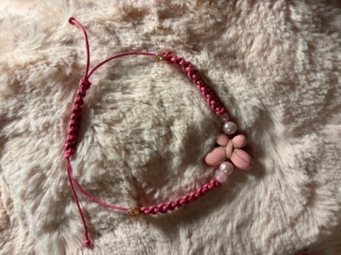 Pink beaded bracelet with stones on a fluffy white surface