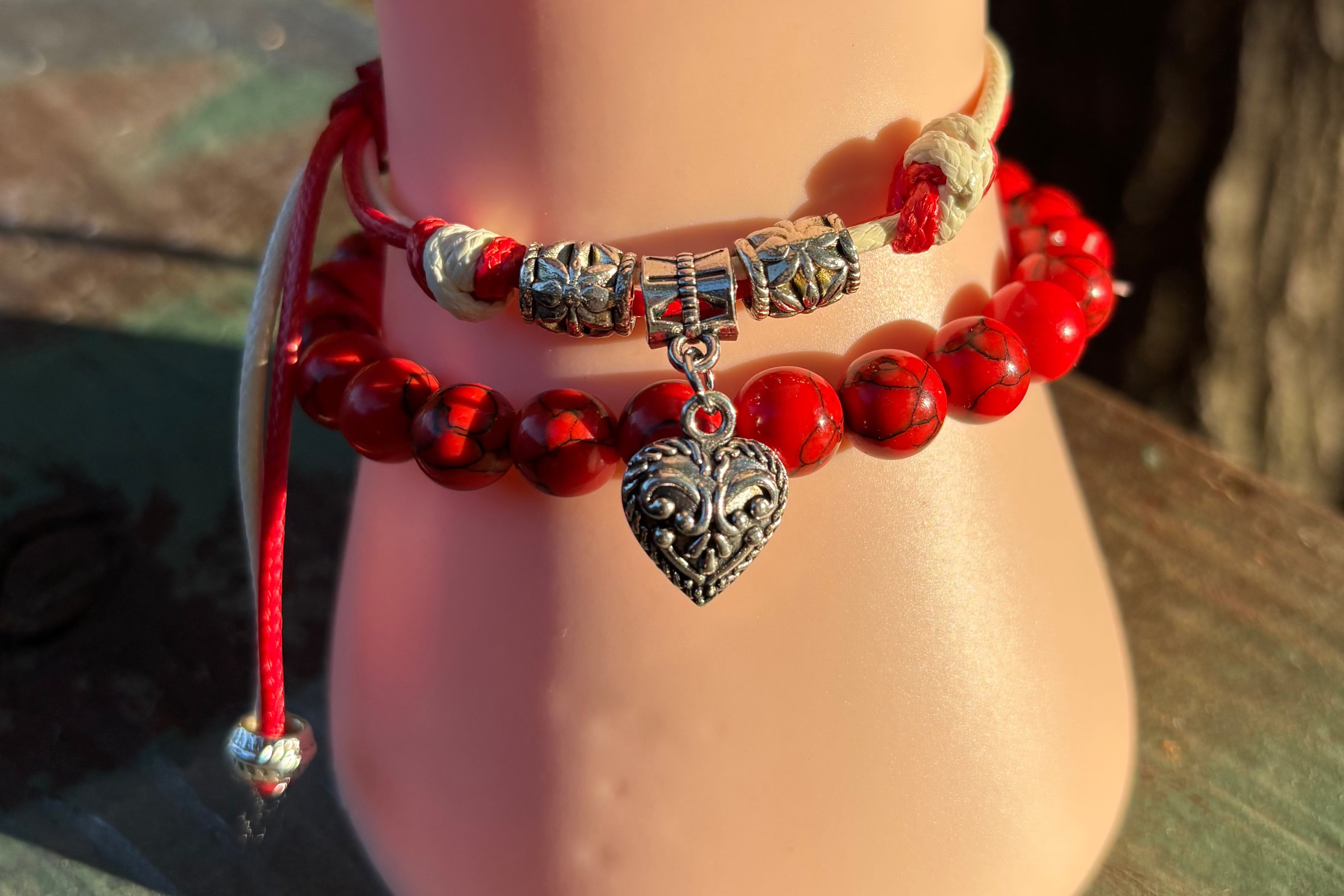 Red beaded bracelet with silver heart charm