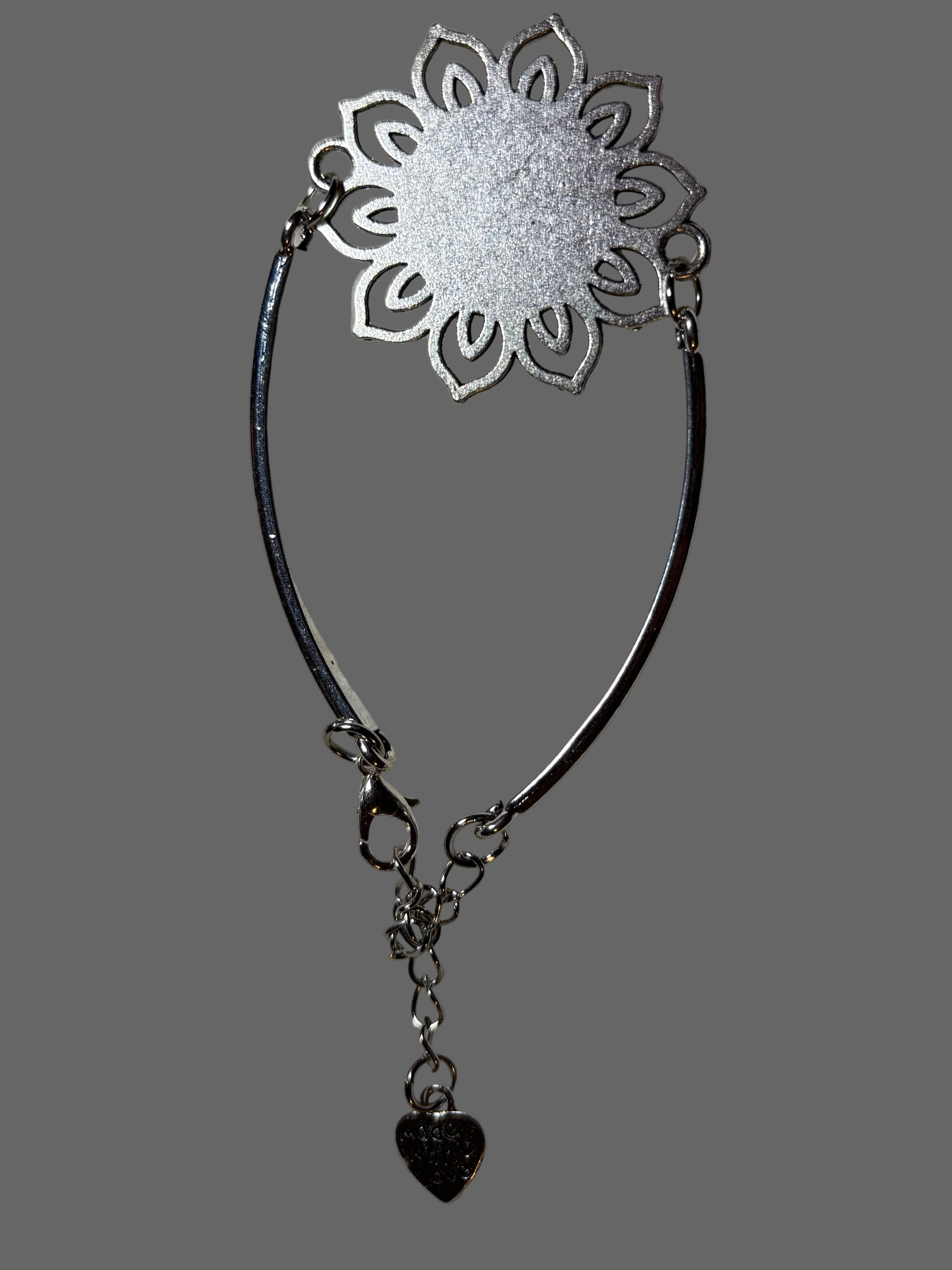 Silver floral headband with a heart charm on a gray background