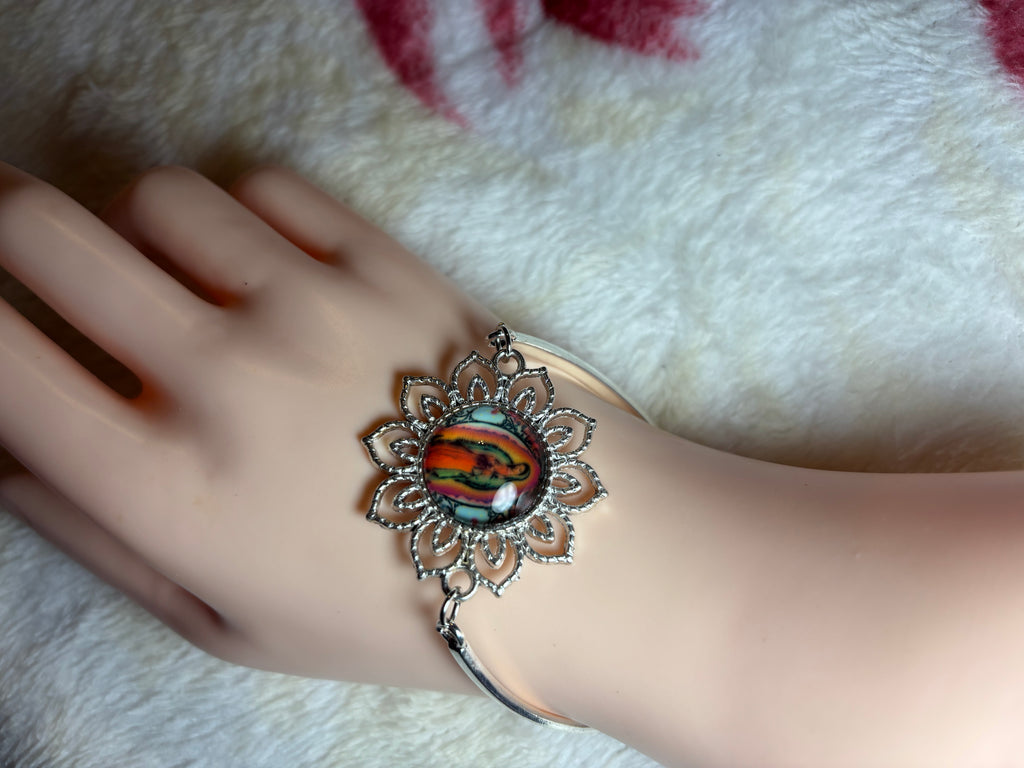 Decorative bracelet on a wrist against a soft fabric background