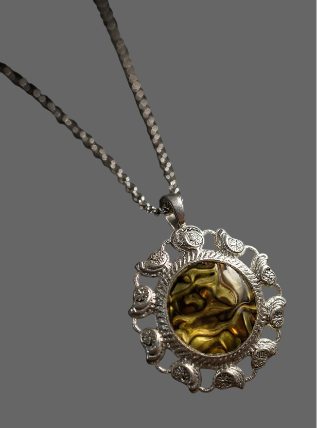 Silver necklace with a round pendant featuring a greenish stone on a gray background