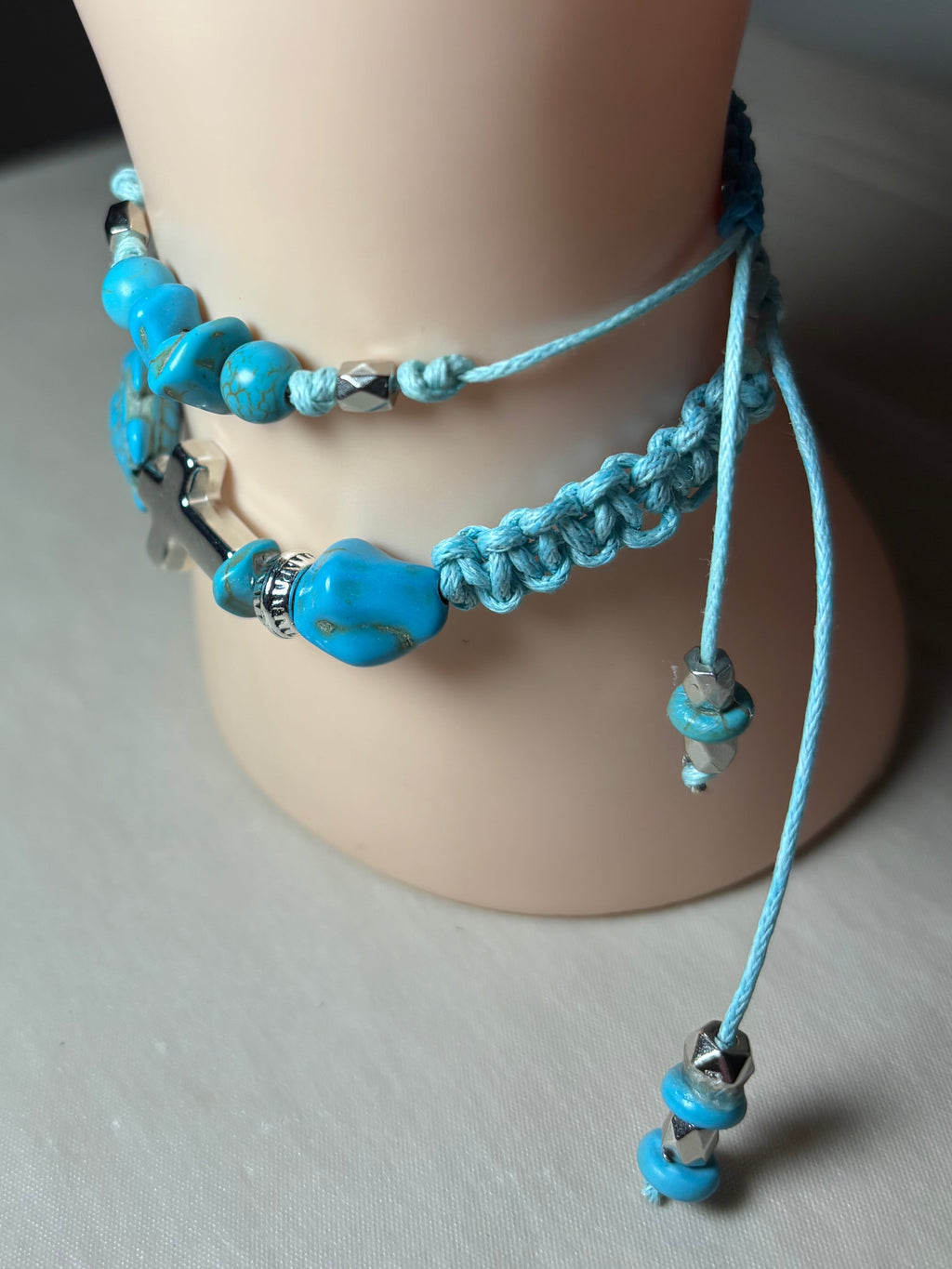 Turquoise beaded bracelet on a wrist with a neutral background